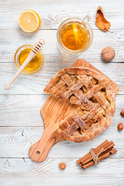 Top view of pie with honey and tea