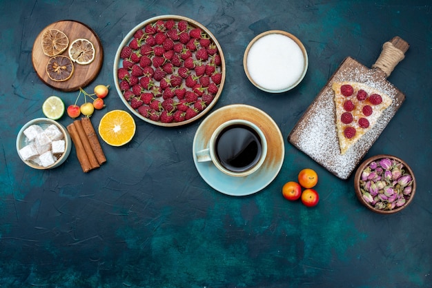 Top view piece of cake baked sweet with raspberries and tea on dark-blue desk berry sugar cake pie bake biscuit