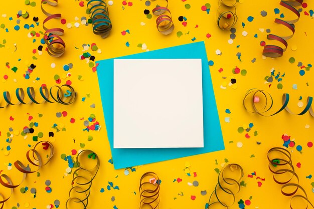 Top view of a piece of paper surrounded by confetti on a yellow background