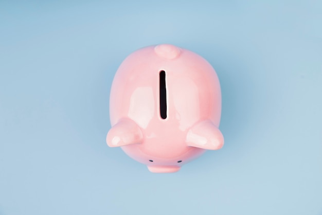 Top view piggy bank on blue wallpaper