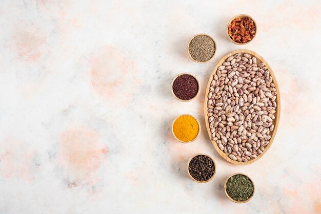 Top view of Pile of Beans with various kinds of spices over white table.