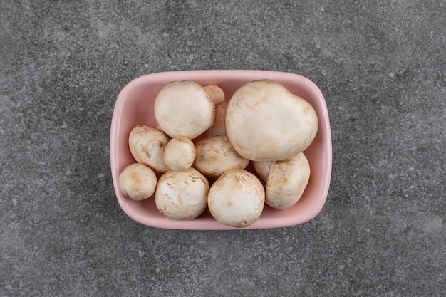 Top view . Pile of fresh organic mushrooms in pink bowl