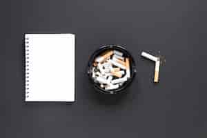 Бесплатное фото Вид сверху кучу сигарет с блокнотом