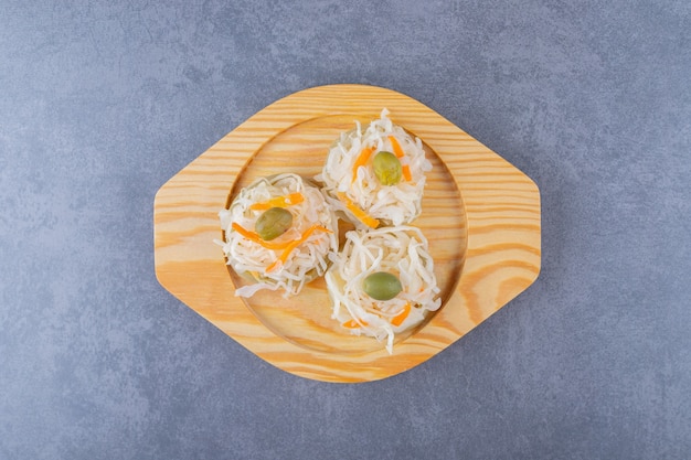 Top view of pile of sauerkraut on wooden plate.