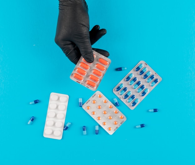 Top view pills in hands with black gloves. horizontal