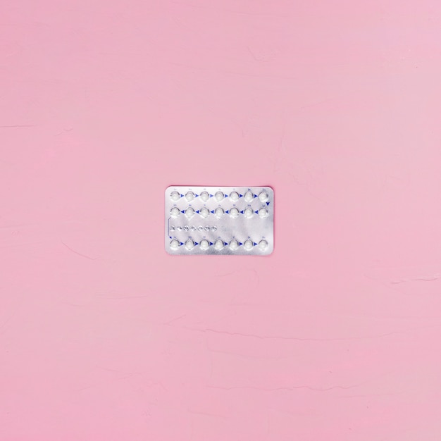 Top view pills on pink background