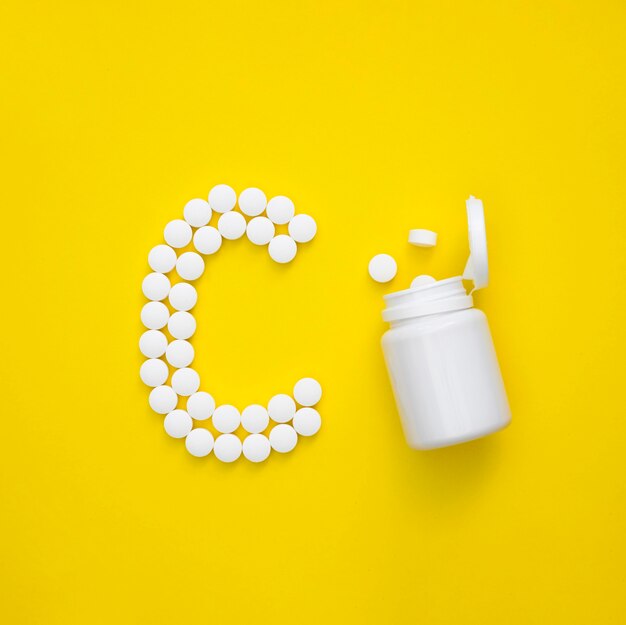 Top view of pills spelling letter and plastic container