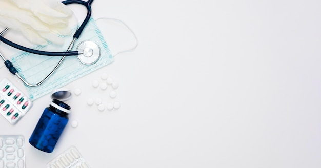 Top view of pills with stethoscope and medical mask