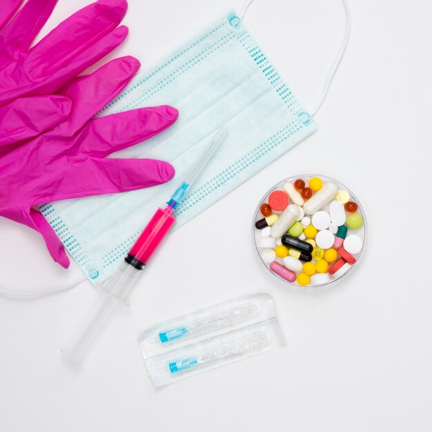 Top view of pills with surgical gloves and medical mask