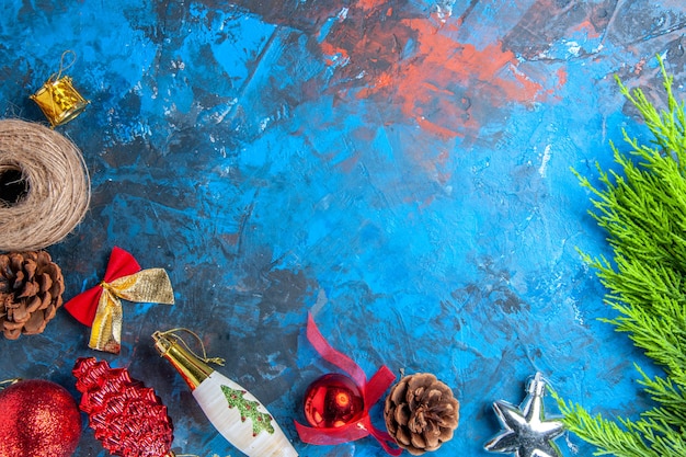 상위 뷰 소나무 나뭇가지 솔방울 짚 스레드 크리스마스 파란색-빨간색 표면에 장식품을 매달려