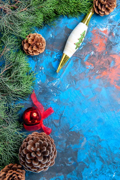 Top view pine tree branches with pinecones on blue-red surface