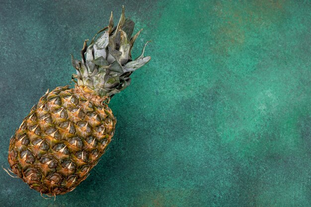 Top view of pineapple on green surface