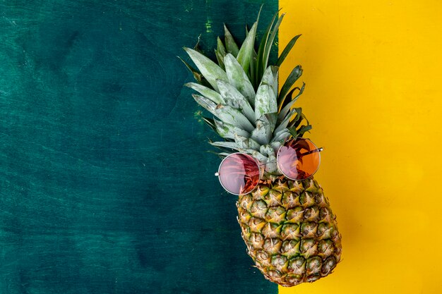 Top view of pineapple with red glasses