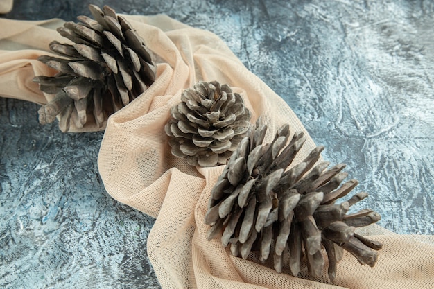 Top view pinecones on beige shawl on dark surface