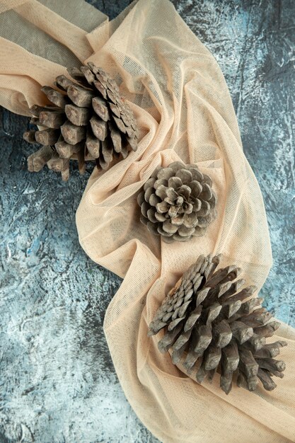 Top view pinecones on beige shawl on dark surface