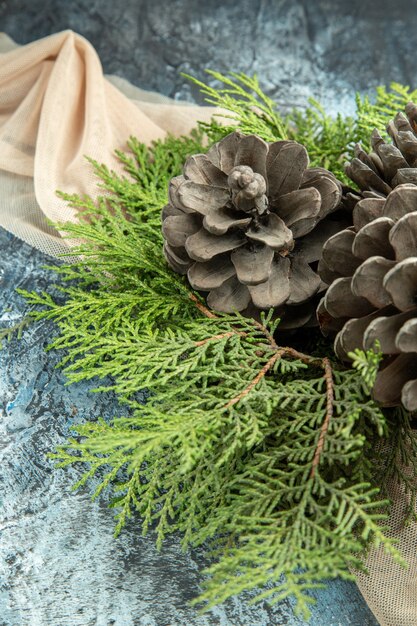 Top view pinecones pine branches on beige shawl on dark surface