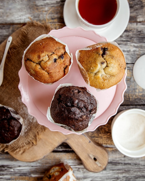 Top view of pink cake stand with three muffins