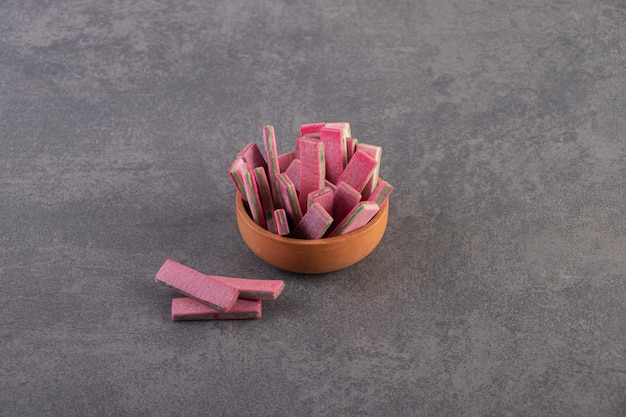 Top view of pink gums in bowl over grey surface