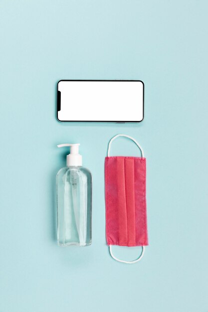 Top view pink medical mask with blank phone