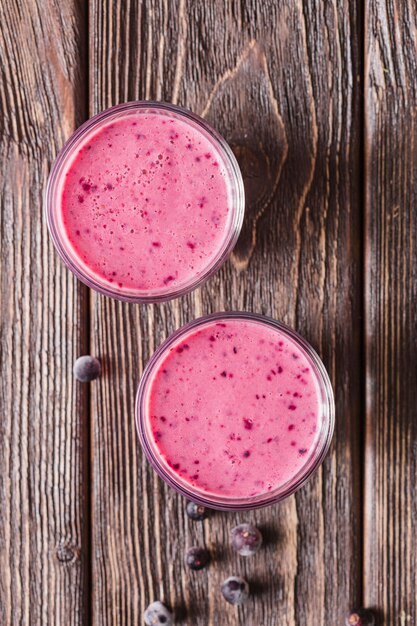 Top view pink smoothie in glasses with blueberries