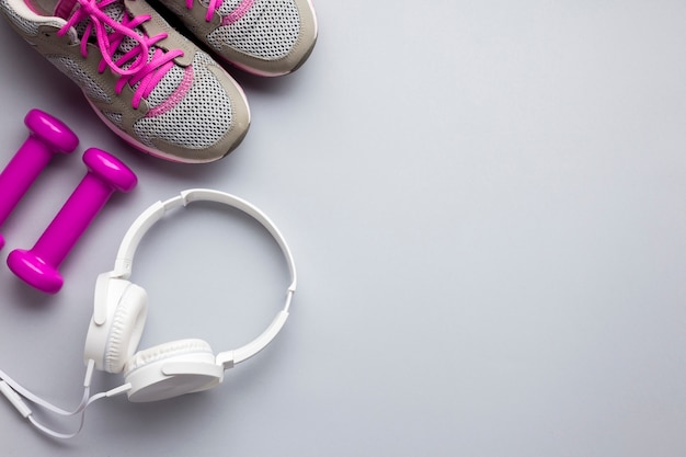 Top view pink sports attributes with headphones