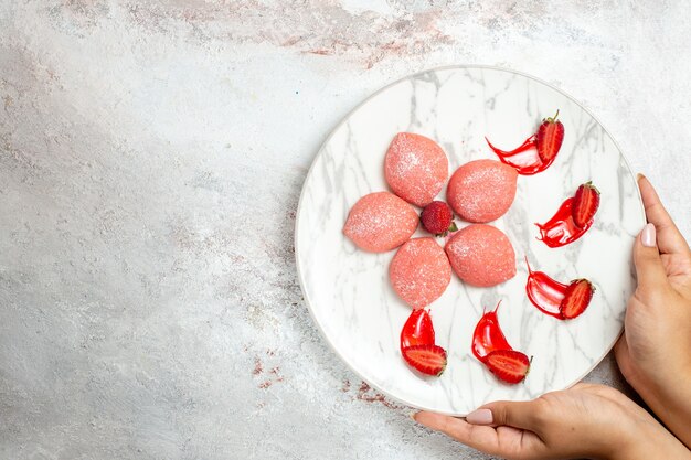 Top view pink strawberry cakes little delicious sweets on white background biscuit sugar tea sweet cookie cake