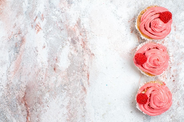 免费照片顶视图白色表面上粉红色的草莓奶油蛋糕