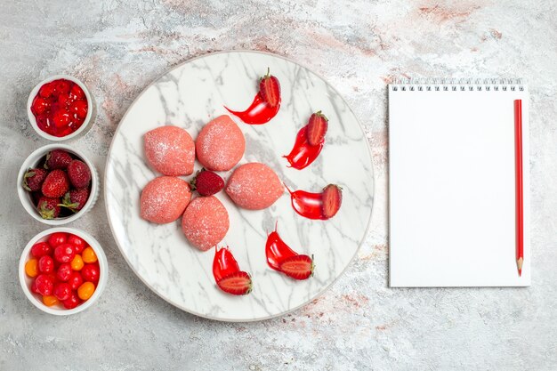 Top view pink strawberry cakes with fruits on light-white background cake sugar cookie tea biscuit sweet