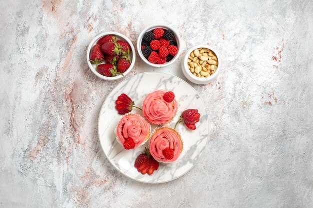 흰색 표면에 견과류와 핑크 딸기 케이크의 상위 뷰