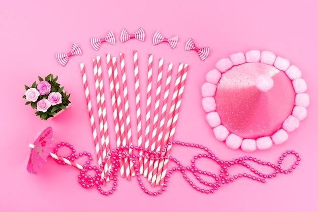 Free photo a top view pink-white stick candies along with birthday cap cute pink, bows on pink, birthday color