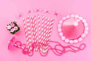 Free photo a top view pink-white stick candies along with birthday cap cute pink, bows on pink, birthday color