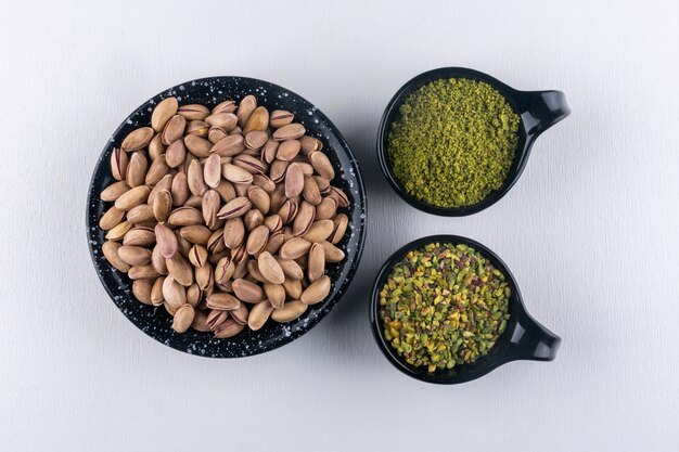 Free photo top view pistachios in a bowl on white