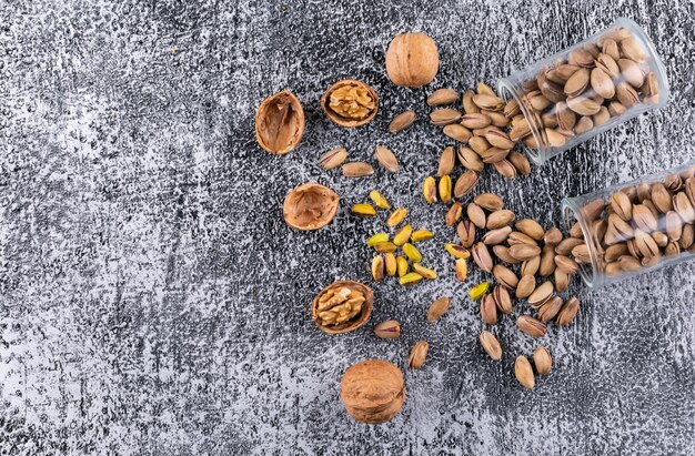 Top view pistachios and walnut in glass on gray texture  horizontal 1