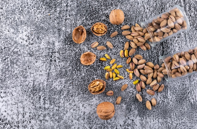 Top view pistachios and walnut in glass on gray texture  horizontal 1