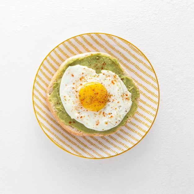 Top view pita with avocado and fried egg on plate