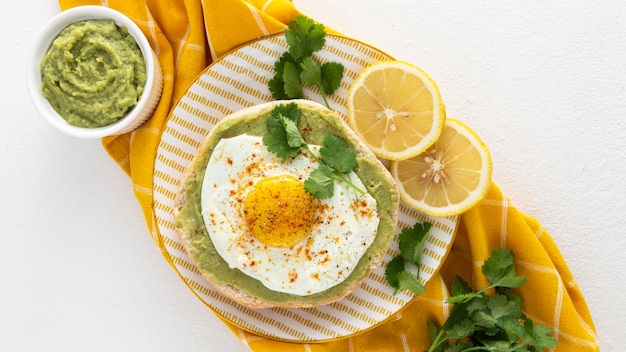 Top view pita with avocado spread and fried egg on plate