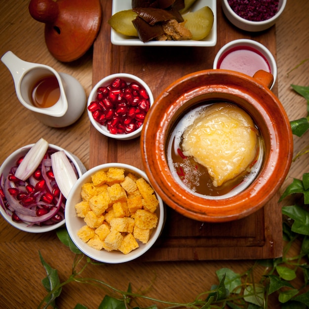 Free photo top view piti with crackers and pomegranate seeds and vinegar in clay jug