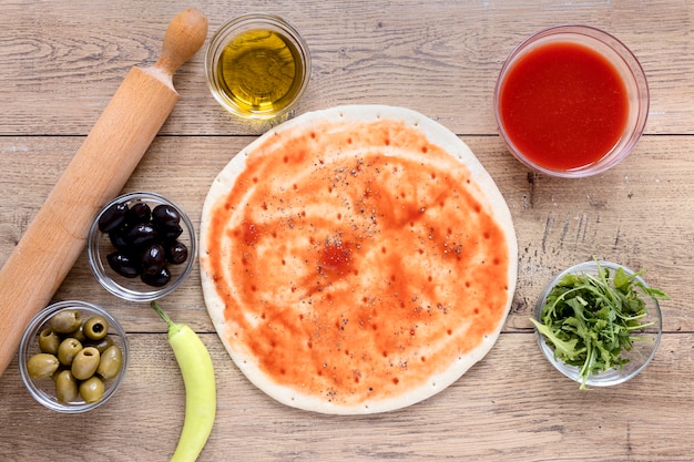 Foto gratuita vista dall'alto pasta per pizza con salsa