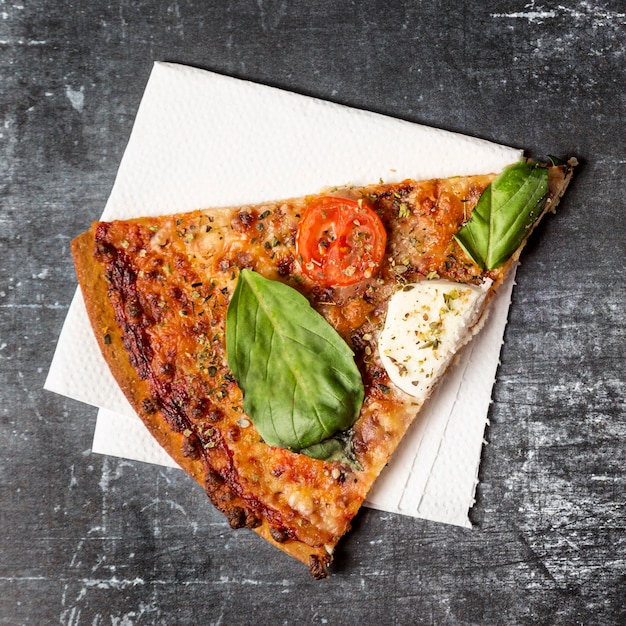 Foto gratuita fetta di pizza vista dall'alto sul tovagliolo