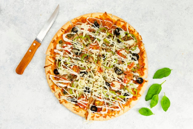 Free photo top view of pizza with knife and mint