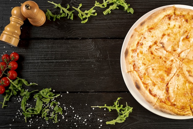 Top view of pizza on wooden table with copy space