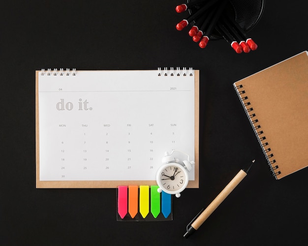 Foto gratuita calendario planner vista dall'alto su sfondo scuro