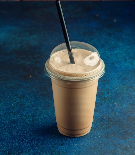 黒いストローでコーヒーカフェラテのプラスチックカップのトップビュー