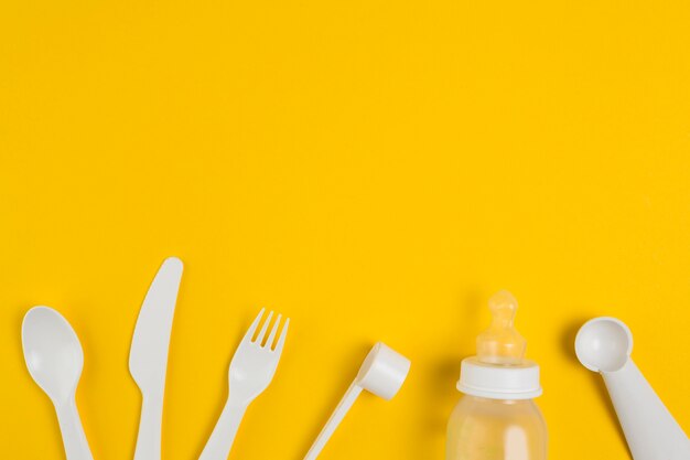 Top view of plastic cutlery and baby bottle for baby shower