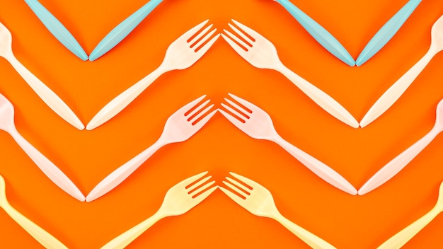 Top view of plastic fork on orange background