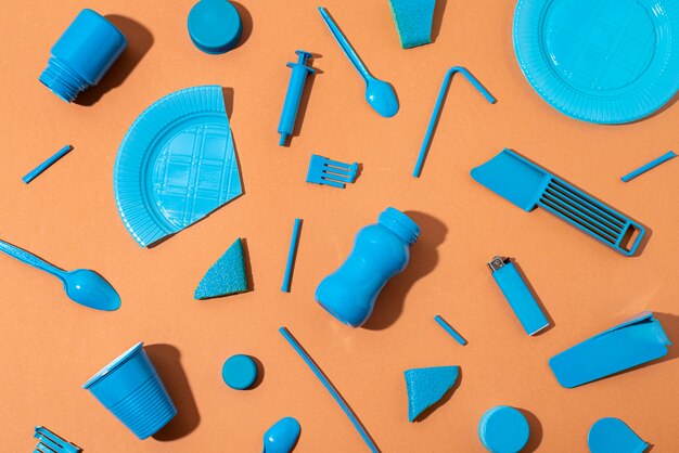 Top view plastic items on orange background