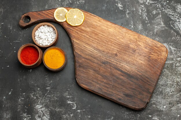 Top view of plate stand with lemon on it and herbs on side on dark grey table