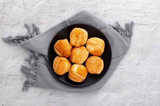 Top view plate with baked buns and cloth