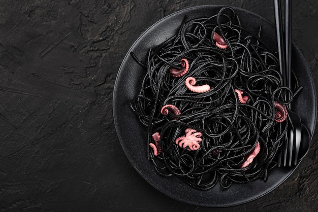 Top view of plate with black spaghetti and squid