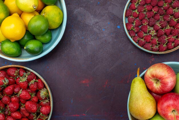 Top view plate with fruits pears and apples with citruses and berries on dark desk